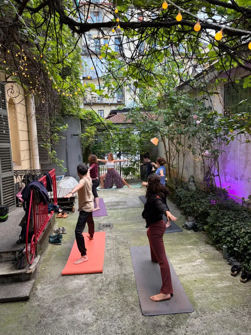 Lezione di yoga di gruppo in cortile a Torino